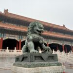 Large stone imperial lion statue infront of a temple at The Forbidden City, Beijing.