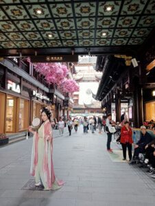 A lady poses in a kimono with a fan in a shopping centre, China