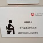 A sign showing how to sit on a western style toilet in China.